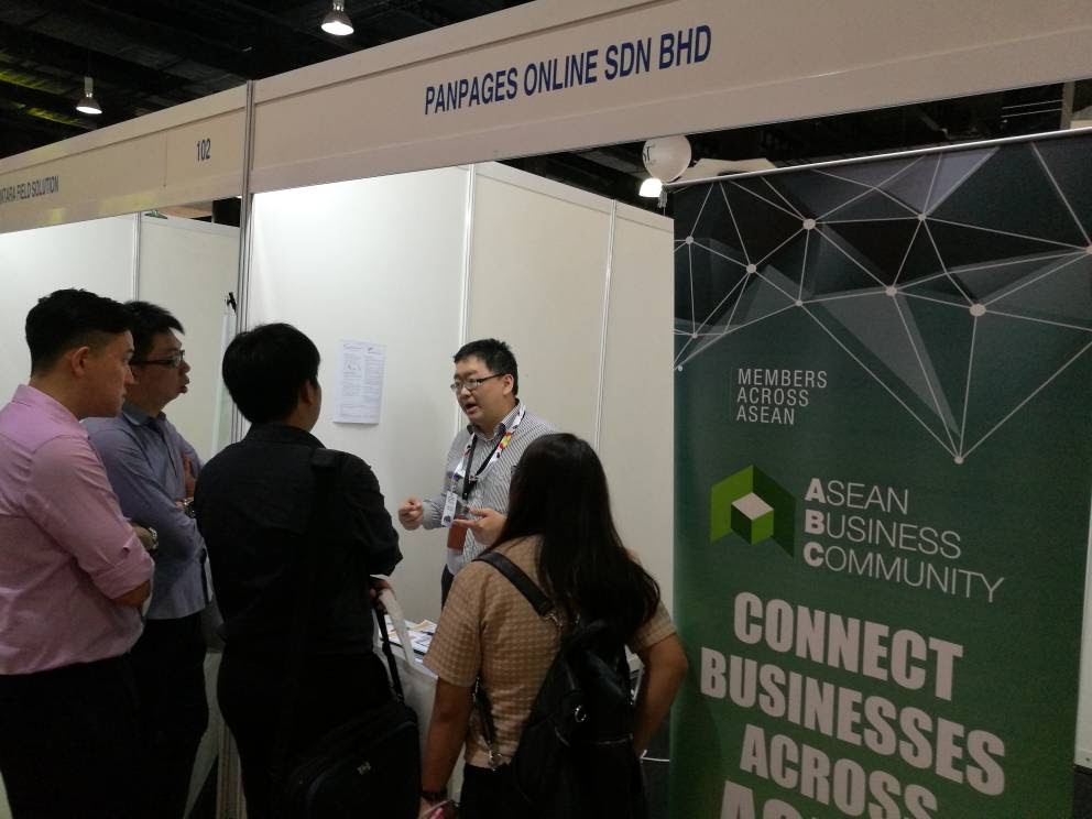 Eric Low speaking with visitors at a PanPages business exhibition booth